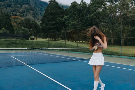 A youthful tennis player in a white outfit on a blue court, joyfully holding a ball, amidst green scenery and mountains, capturing the spirit of the game and summer