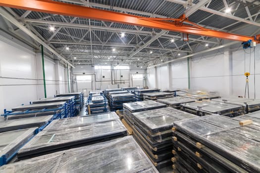 Interior of a storage warehouse with pvc windows wrapped in stretch film, placed on pallets and ready for shipping