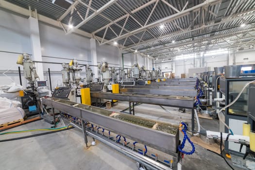 Inside a modern factory, extrusion lines are actively producing plastic products, showcasing advanced industrial technology