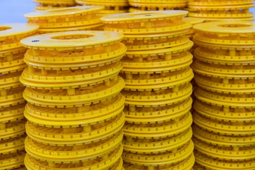 Vibrant yellow plastic rings stacked high, showcasing precision and uniformity in a manufacturing or storage setting