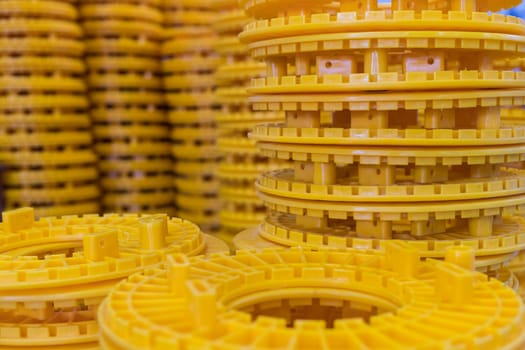 Stacks of identical yellow plastic parts, showcasing industrial manufacturing, warehousing, and distribution processes