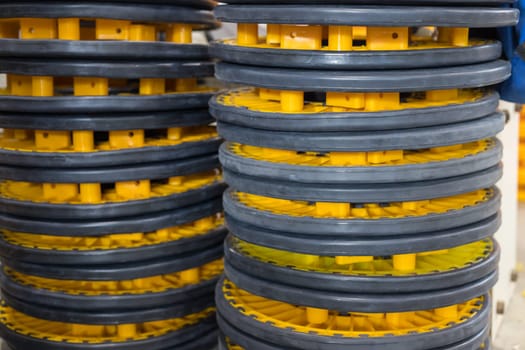 Stacks of rubber wheels with yellow plastic hubs create an industrial pattern