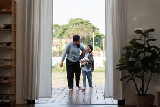 A mother and her son share a tender moment as they step onto the porch, ready for an outdoor adventure, highlighting their close bond.