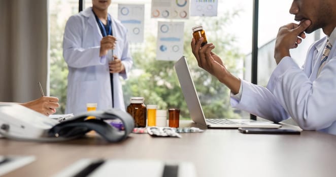 A doctor thoughtfully analyzing medication options during a meeting with colleagues, focusing on patient care and treatment strategies.