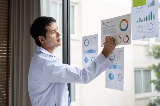 A diligent doctor writing insights from a thorough data analysis on a report in a hospital, aiming to enhance patient care and service delivery.