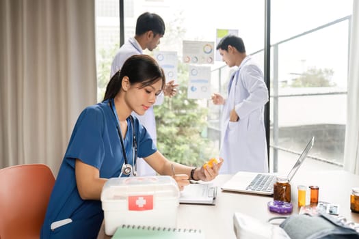 A doctor analyzing patient medication while taking notes on health data during a collaborative team meeting in an office.