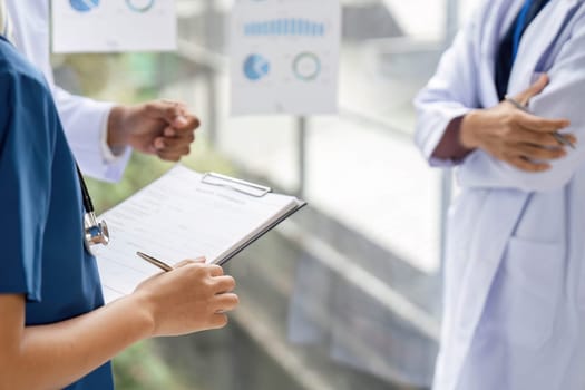 A doctor explaining patient care strategies with the help of charts and visuals, showcasing clear communication and teamwork.