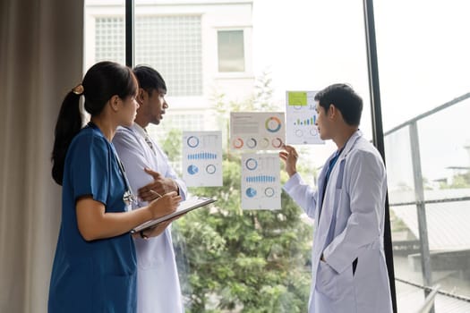 Three medical professionals working together to interpret health charts, emphasizing cooperation and data-driven patient care.