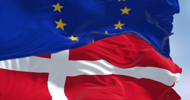 The national flag of Denmark and the flag of the European Union flutter in the wind. 3D rendered illustration. Selective focus. Fluttering fabric. EU membership
