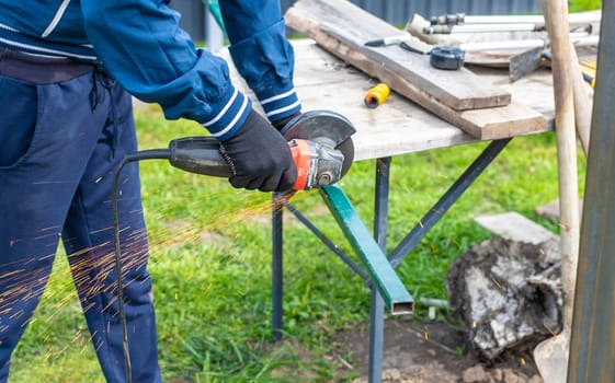A man works with a grinder on metal. Selective focus. people.
