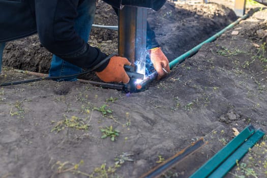 A man doing welding work. Selective focus. People.
