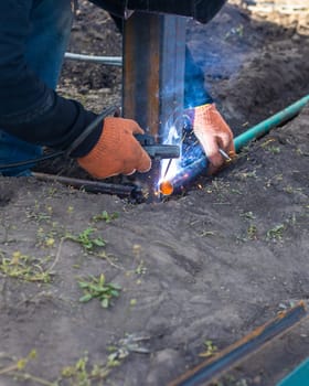 A man doing welding work. Selective focus. People.