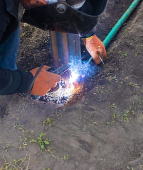 A man doing welding work. Selective focus. People.