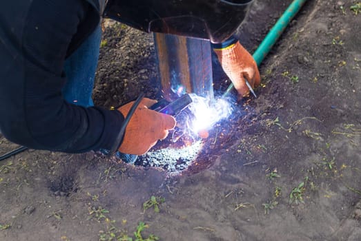 A man doing welding work. Selective focus. People.