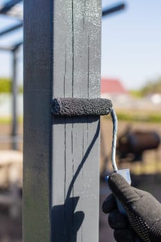 Man painting wooden poles. Selective focus. people.