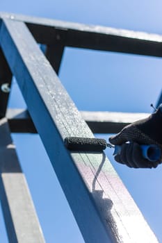 Man painting wooden poles. Selective focus. people.