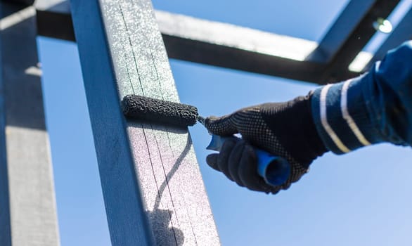 Man painting wooden poles. Selective focus. people.