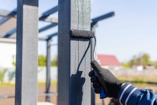 Man painting wooden poles. Selective focus. people.