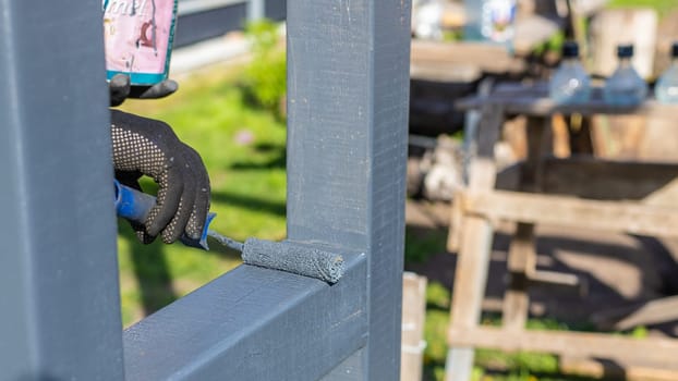 Man painting wooden poles. Selective focus. people.