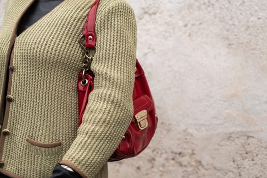 Milan, Italy - March, 28, 2024: Woman wears red handbag. Fashion outfit details, street style