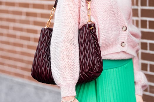 Milan, Italy - February, 21, 2024: Woman wears burgundi leather bag. Fashion outfit detail, street style