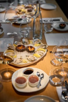 Champagne tasting, Wine glasses are on the table, stylish table setting, sparkling wine bubbles, oysters and sea urchins, special sauce. High quality photo