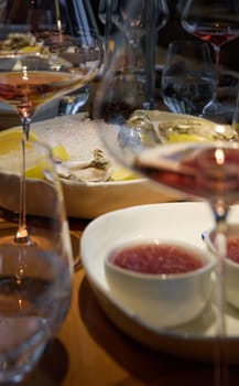 Champagne tasting, Wine glasses are on the table, stylish table setting, sparkling wine bubbles, oysters and sea urchins, special sauce. High quality photo