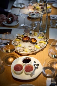 Champagne tasting, Wine glasses are on the table, stylish table setting, sparkling wine bubbles, oysters and sea urchins, special sauce. High quality photo