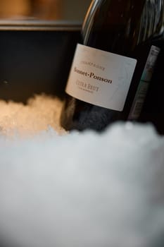 Russia, St.Petersburg, 29 April 2025: Bottle of champagne brand Bonnet-Ponson is cooled in a niche with ice in the restaurant, local lighting, wine cabinet, decanters for sparkling wine. High quality photo