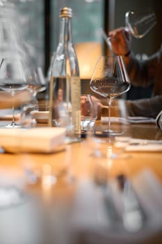Champagne tasting, Wine glasses are on the table, stylish table setting, A man's hand holds a beautiful elegant glass with rose sparkling wine, an intimate light, a plate with oysters and lemon. High quality photo