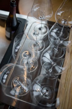 Clean wine glasses are on the table of a special wine cabinet, stylish table setting, ice, bottle of sparkling wine, light from window, decoder and degasser. High quality photo