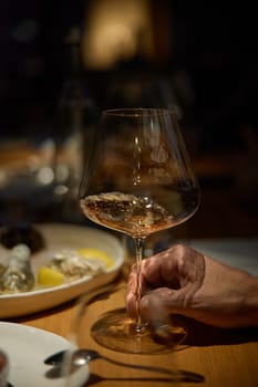 Champagne tasting, Wine glasses are on the table, stylish table setting, wine is poured from a bottle and decanter, sparkling wine bubbles, snacks, people smell the aroma and taste the wine. High quality 4k footage