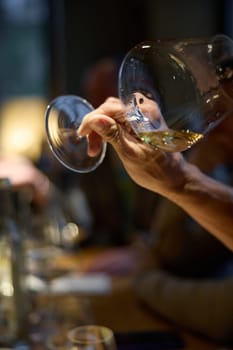 Champagne tasting, Wine glasses are on the table, stylish table setting, A man's hand holds a beautiful elegant glass with rose sparkling wine, an intimate light, a plate with oysters and lemon. High quality photo