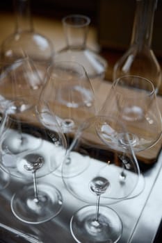 Clean wine glasses are on the table of a special wine cabinet, stylish table setting, ice, bottle of sparkling wine, light from window, decanter and degasser. High quality photo