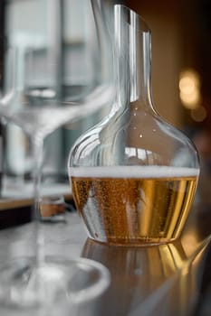 Decanter for sparkling wine on the table, Champagne tasting, Wine glasses, reflections, rose wine. High quality photo