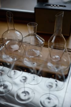 Clean wine glasses are on the table of a special wine cabinet, stylish table setting, ice, bottle of sparkling wine, light from window, decanter and degasser. High quality photo
