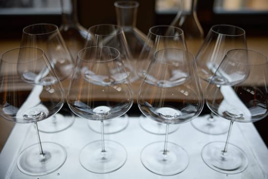 Clean wine glasses are on the table of a special wine cabinet, stylish table setting, ice, bottle of sparkling wine, light from window, decanter and degasser. High quality photo
