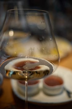 A glass of sparkling wine in close-up, Champagne tasting, Wine glasses are on the table, stylish table setting, sparkling wine bubbles, oysters and sea urchins, special sauce. High quality photo