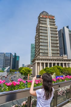 Shanghai, China - 1 April 2025: tourist photographs the Ping An Group building with red Ping An Insurance signage in Pudong on a sunny day