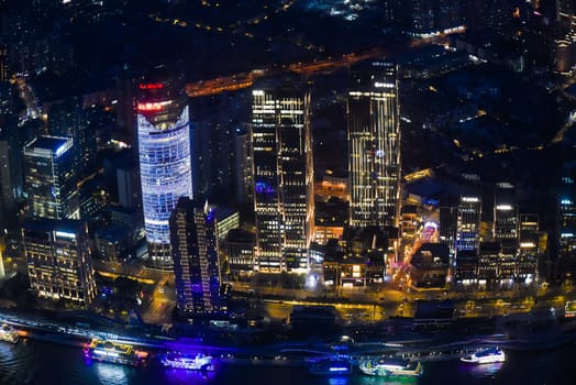 Shanghai, China - 1 April 2025: Neon-lit Pudong skyline reflects on Huangpu River at night, showcasing modern skyscrapers and urban vibrancy