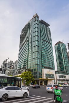 Shanghai, China - 1 April 2025: The Eton Hotel Shanghai in Pudong business district with urban traffic and delivery driver at busy city intersection