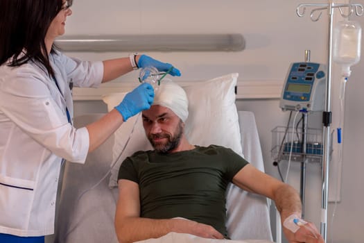 A patient with their head bandaged is receiving essential medical treatment and care from a professional nurse
