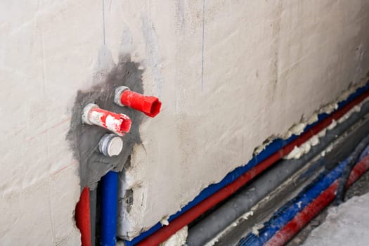 There is a wall that has a large number of pipes protruding from its surface, creating an intricate network of utilities and connections