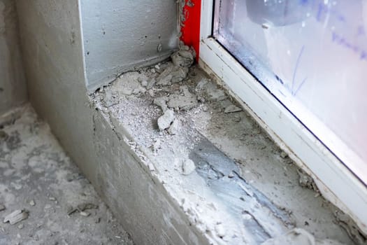 There is a window sill that has an abundant amount of concrete accumulated on its surface, which raises various concerns