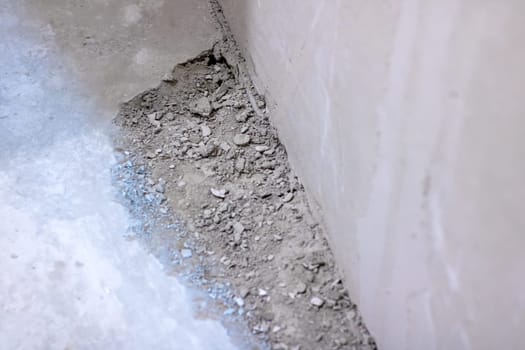 This is a closeup view of a rough concrete surface, which features a few small rocks scattered upon it, adding texture and interest