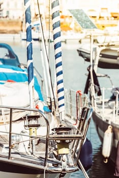 Sailboat deck with striped sails and harbor background, 