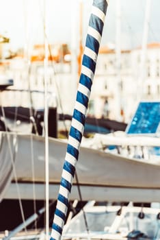 Sailboat mast with blue and white stripes in marina, nautical theme, 