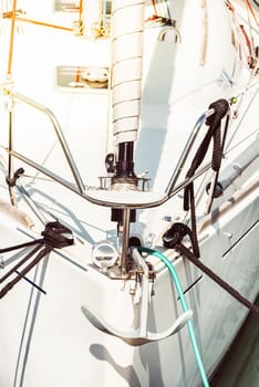 Sailboat anchor detail with ropes and white hull, suitable for background, 
