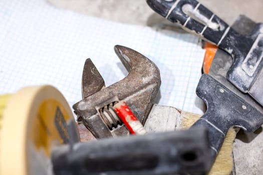 A metal wrench is resting on a piece of graph paper, which is used for drawing accurate illustrations and designs in various fields