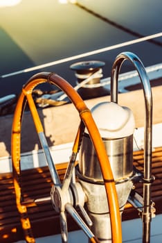 Sailboat steering wheel and rigging lit by warm sunlight, perfect for nautical themes, 